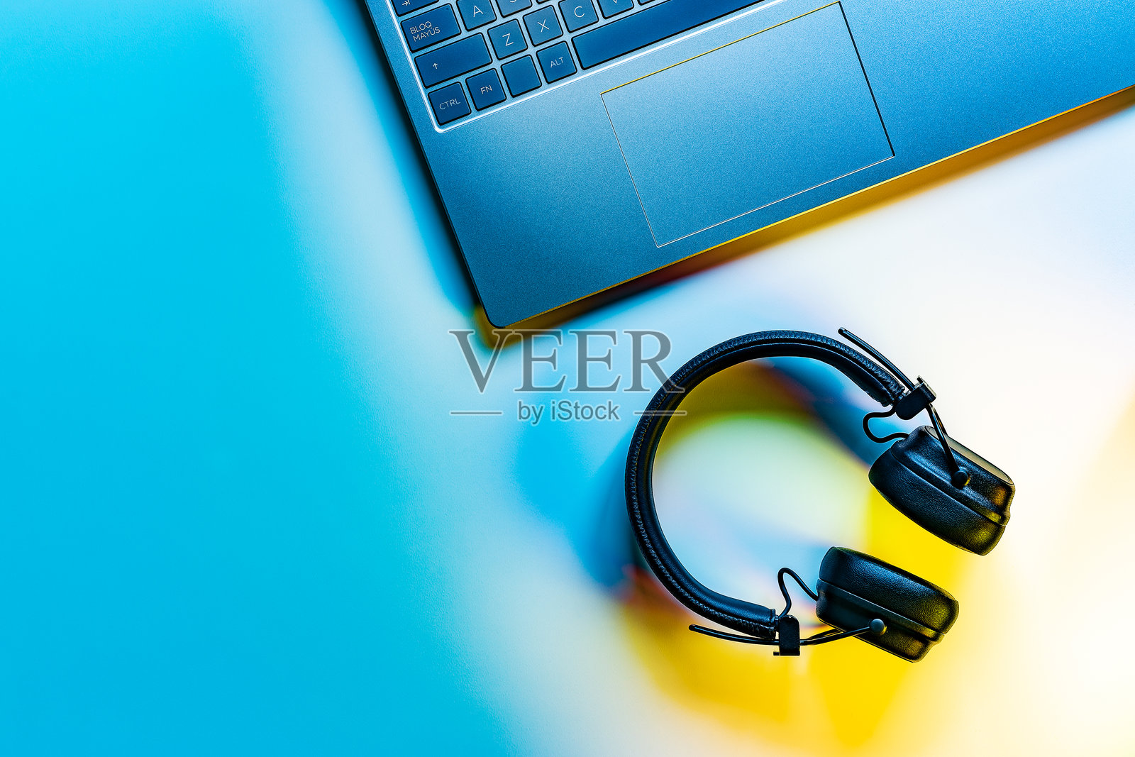 笔记本电脑和无线耳机，沉浸式音频体验。照片摄影图片