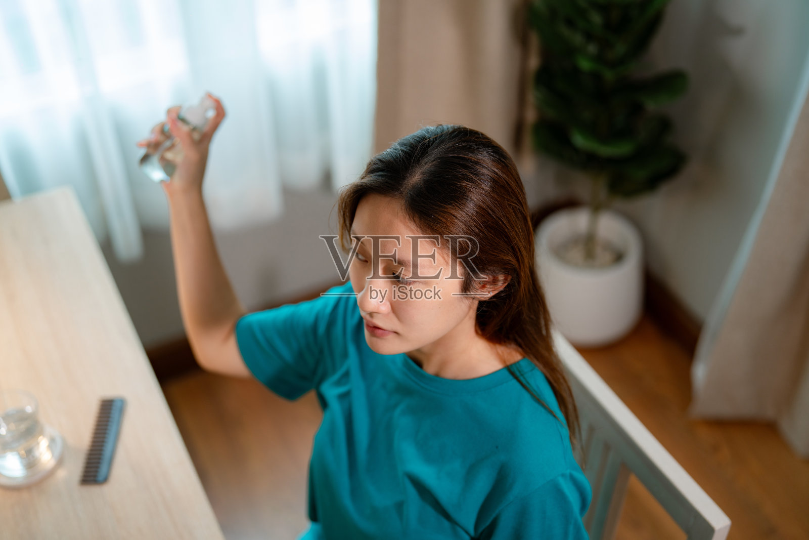 亚洲女性在头发上喷发胶照片摄影图片