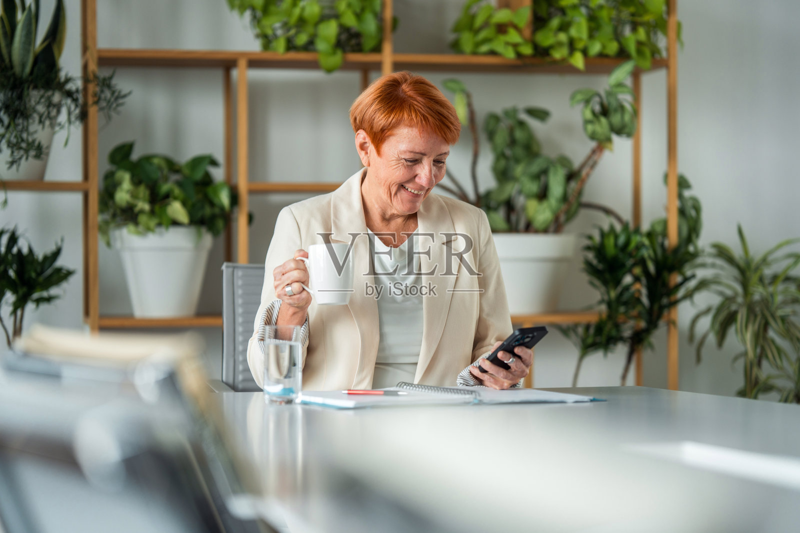 成熟的女商人正在喝咖啡工作照片摄影图片