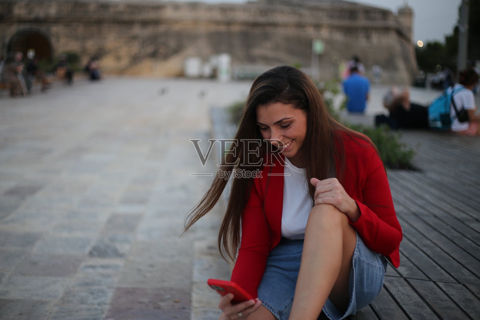 美丽的女性在城市街道上使用手机。照片摄影图片