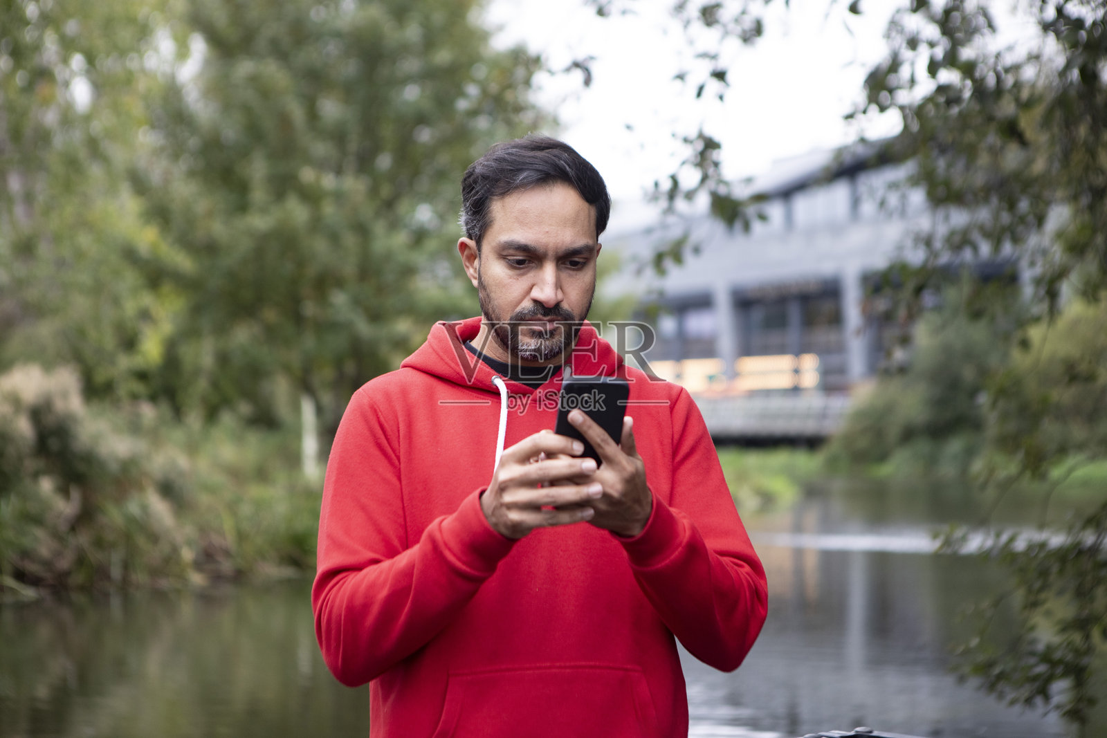 男子在城市的河边使用智能手机照片摄影图片