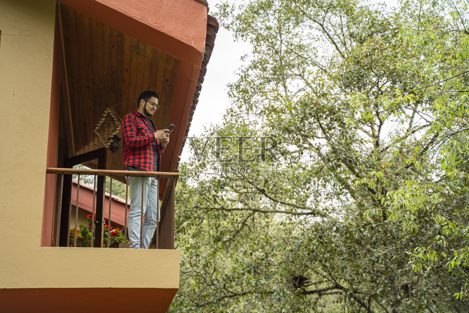 年轻男子在家阳台上使用手机照片摄影图片