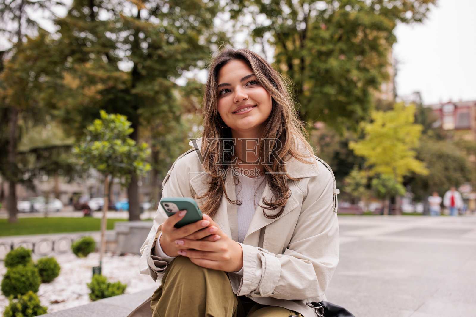 年轻女性在公园里使用手机照片摄影图片