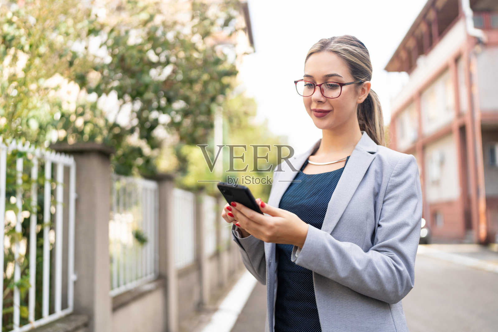 年轻的白人女商人在城市通勤时使用手机的肖像照片摄影图片