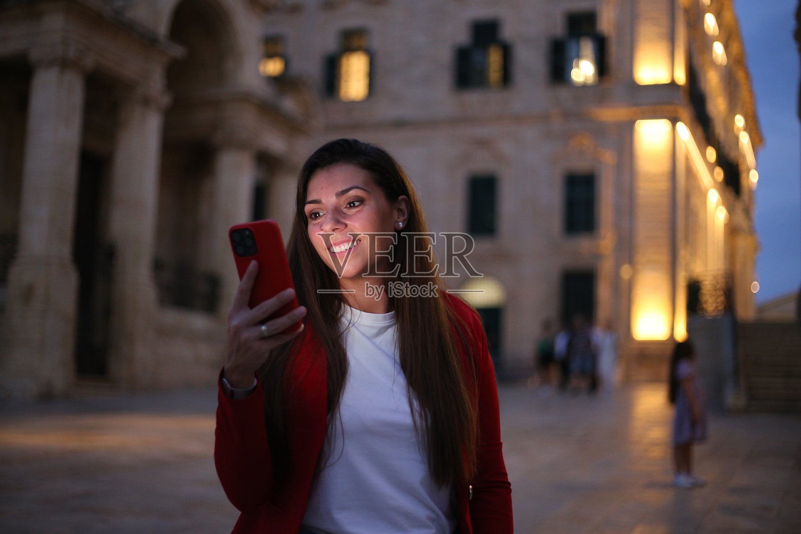 美丽的女性在城市街道上使用手机。照片摄影图片