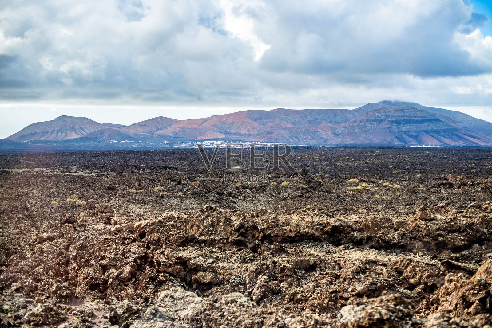 兰萨罗特的火山景观与远处的山脉。照片摄影图片