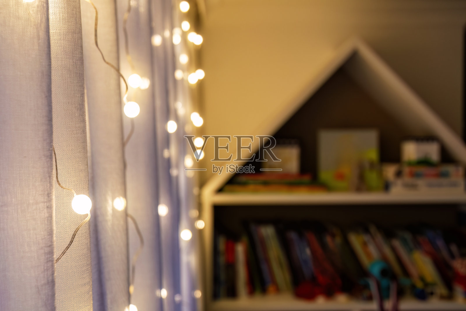 温暖而迷人的画面，房间内轻纱窗帘上悬挂着仙女灯。照片摄影图片