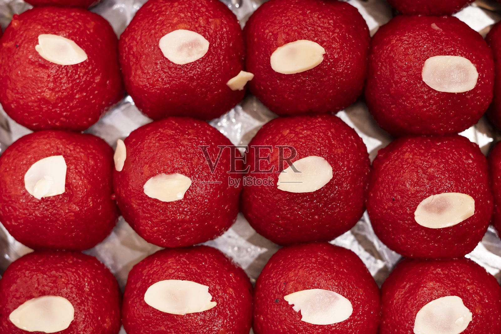 马提丘尔拉杜（Motichoor Laddu）上面撒有坚果的特写，俯视印度、巴基斯坦和孟加拉国的甜点。照片摄影图片