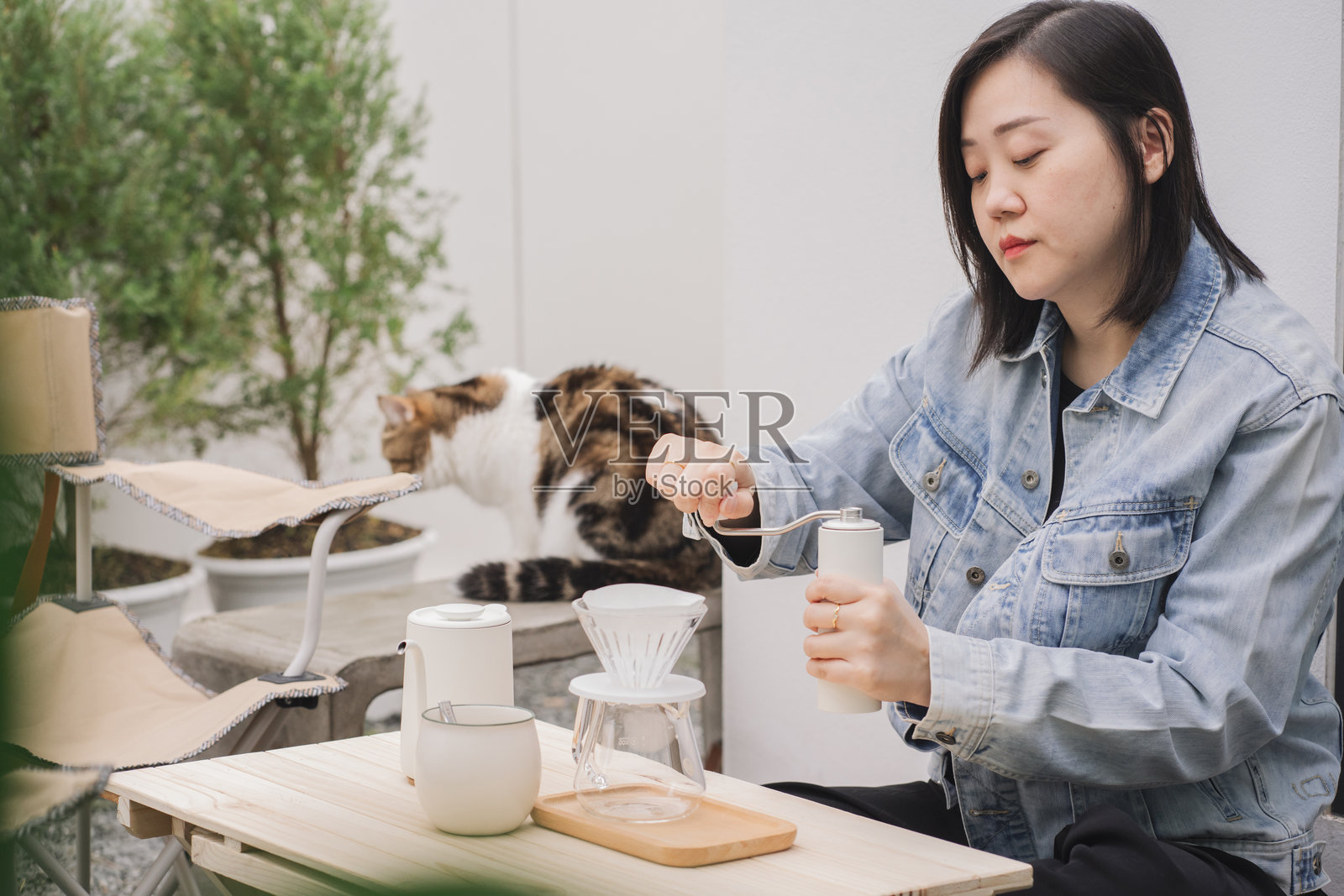 人们的活动概念，亚洲女性在家中与她的猫一起快乐地喝咖啡。照片摄影图片