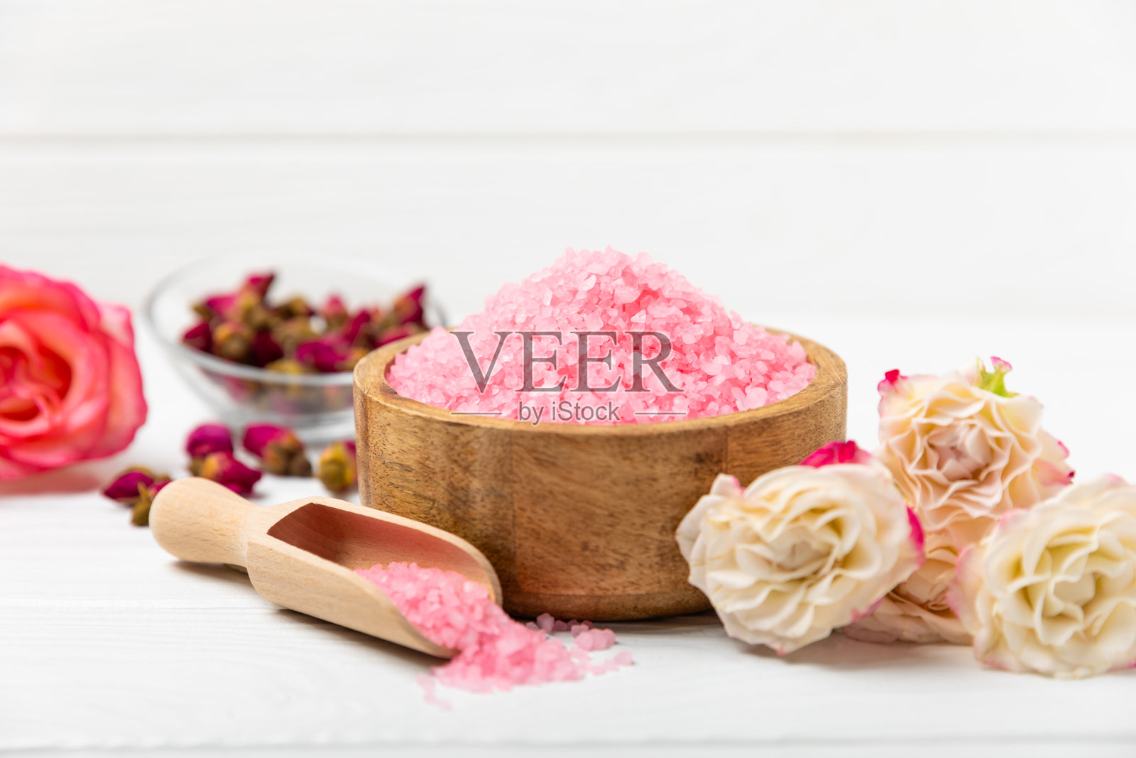 带香气的海盐浴与玫瑰花，背景为纹理木材。粉色海盐。水疗护理。含草药和精油的天然盐。护肤概念。文本的中间留白。照片摄影图片