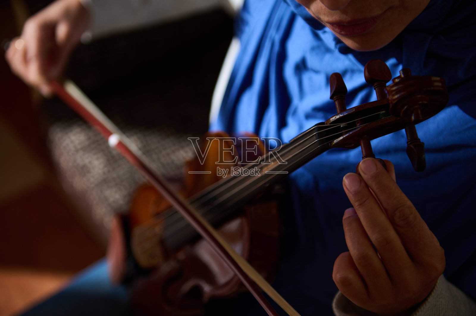 特写镜头，音乐家演奏小提琴，手和弦线聚焦。照片摄影图片