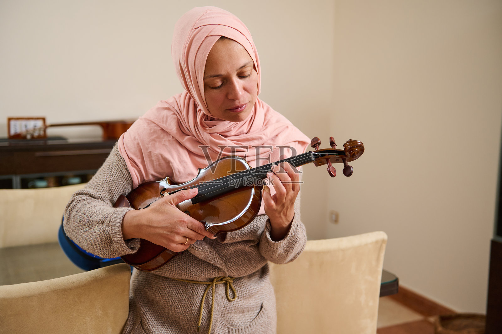 女人在舒适的环境中练习小提琴照片摄影图片