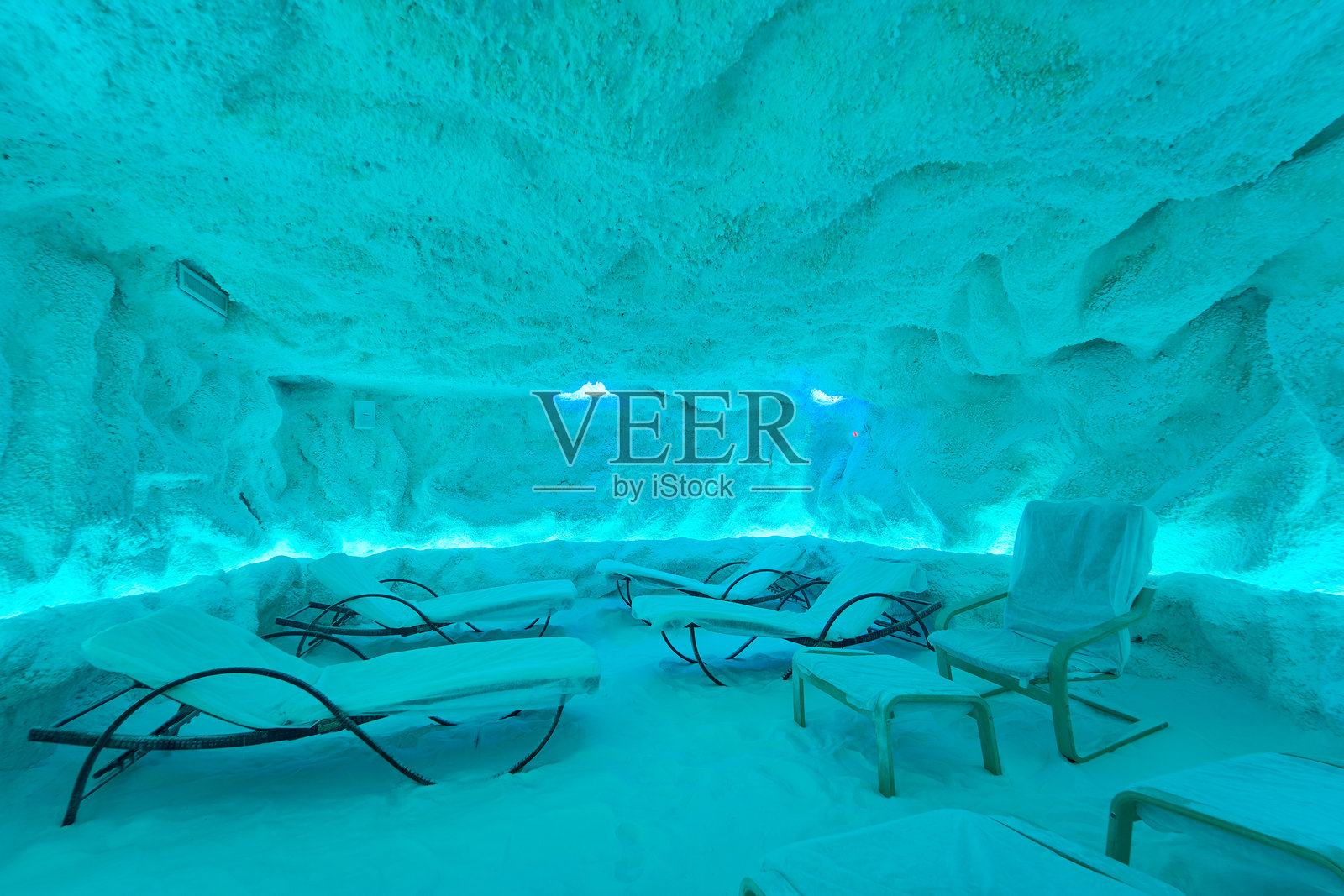 照明盐洞内部，配有休闲椅和治疗氛围照片摄影图片