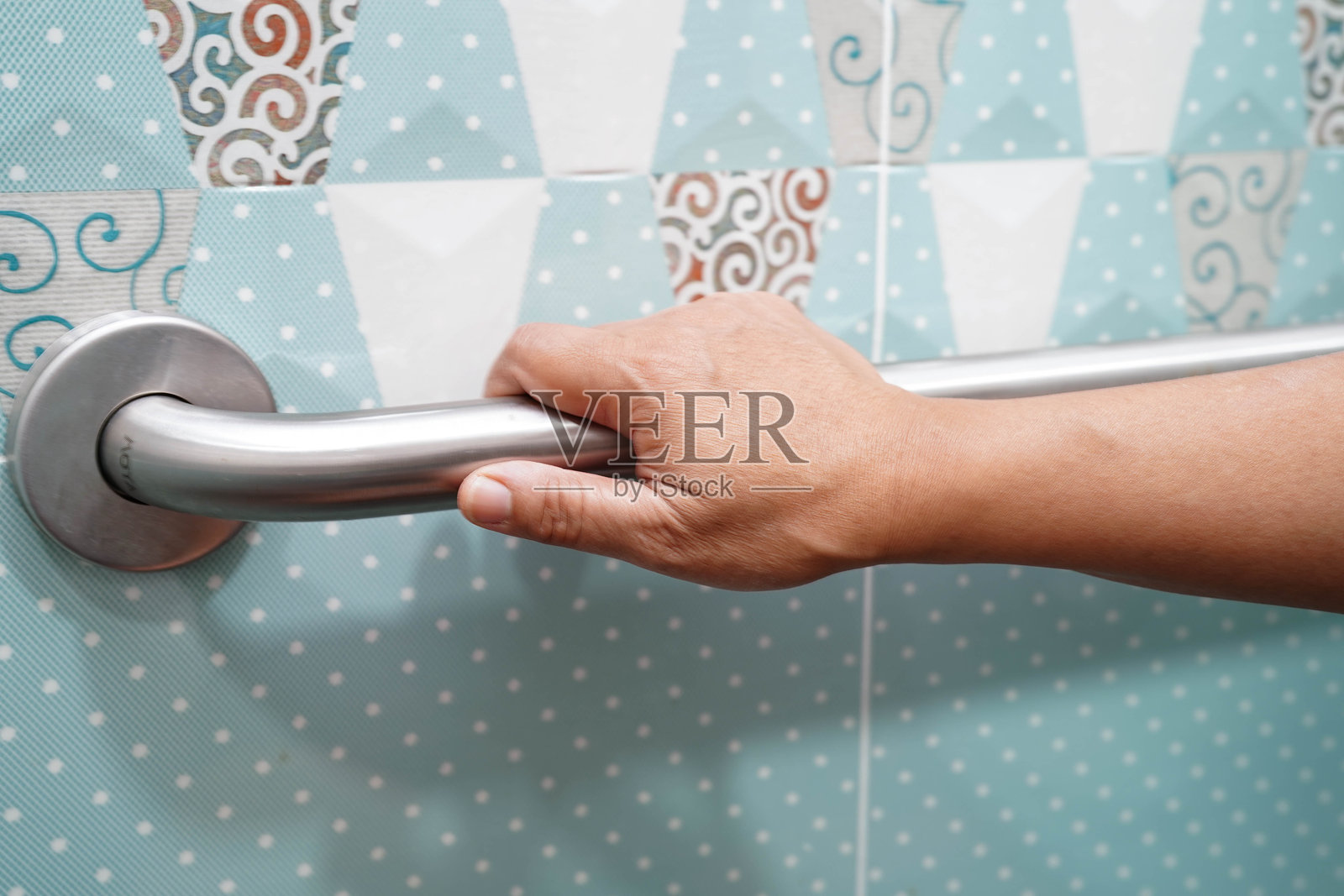 亚洲老年女性患者在浴室使用厕所扶手，安全抓杆，护理医院的安全设施。照片摄影图片