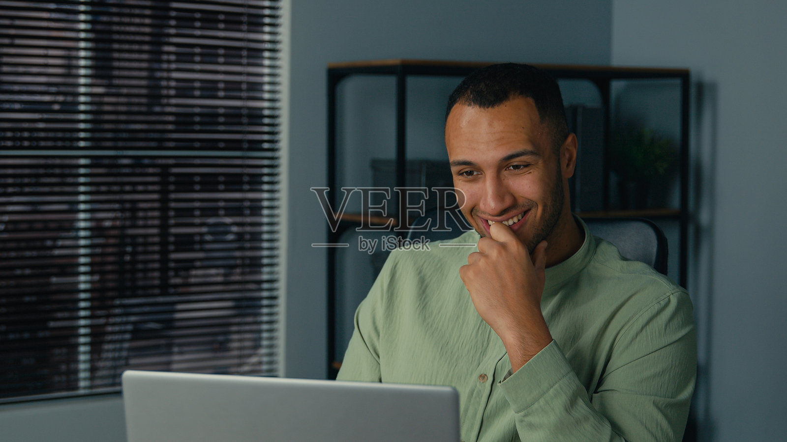 兴奋快乐的非裔美国男商人赢家在办公室查看电子邮件，阅读笔记本电脑上的好消息，庆祝商业成功，在线胜利，获得职业发展新机会和工作邀请。照片摄影图片