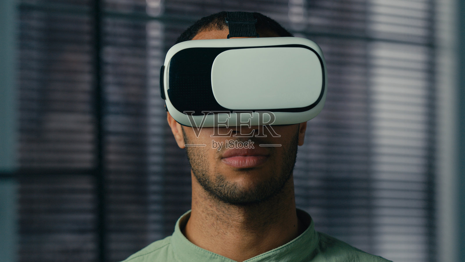 惊讶的非裔美国男性特写，戴着虚拟现实眼镜在数字元宇宙世界中玩视频游戏，作为男性玩家的商人对新创新的3D技术感到惊讶，使用增强现实虚拟现实头盔。照片摄影图片