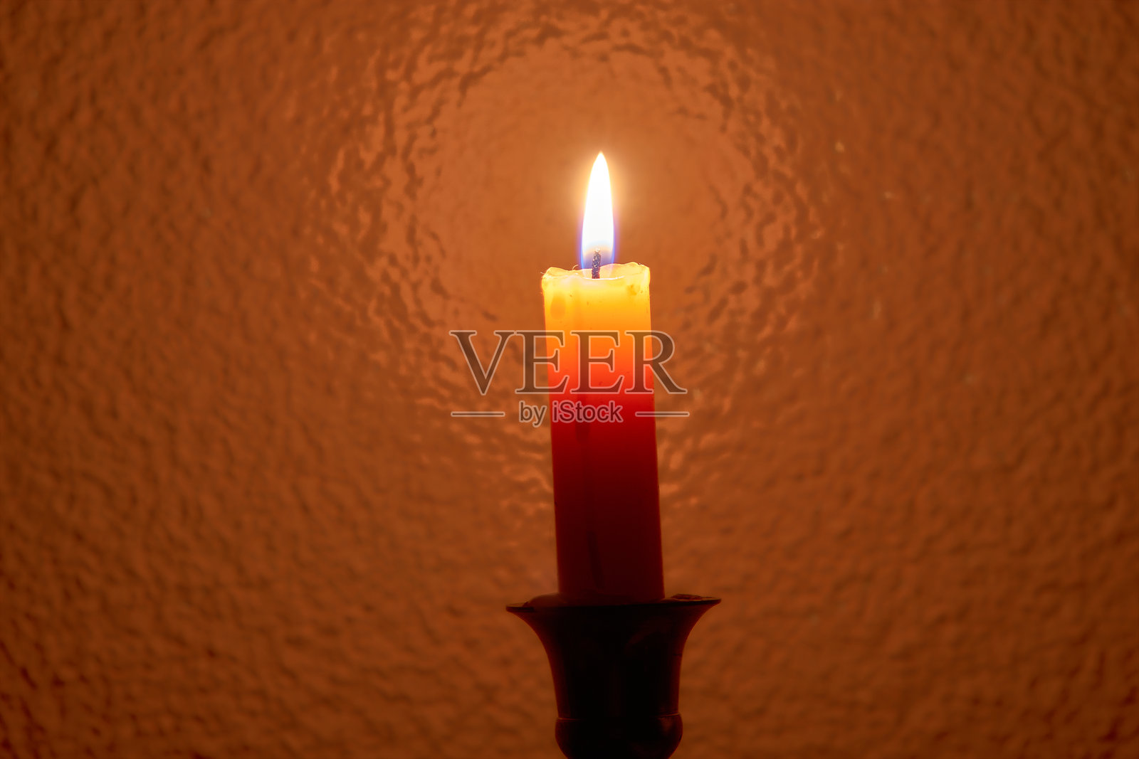 燃烧的蜡烛特写，背景为温暖的橙色调照片摄影图片