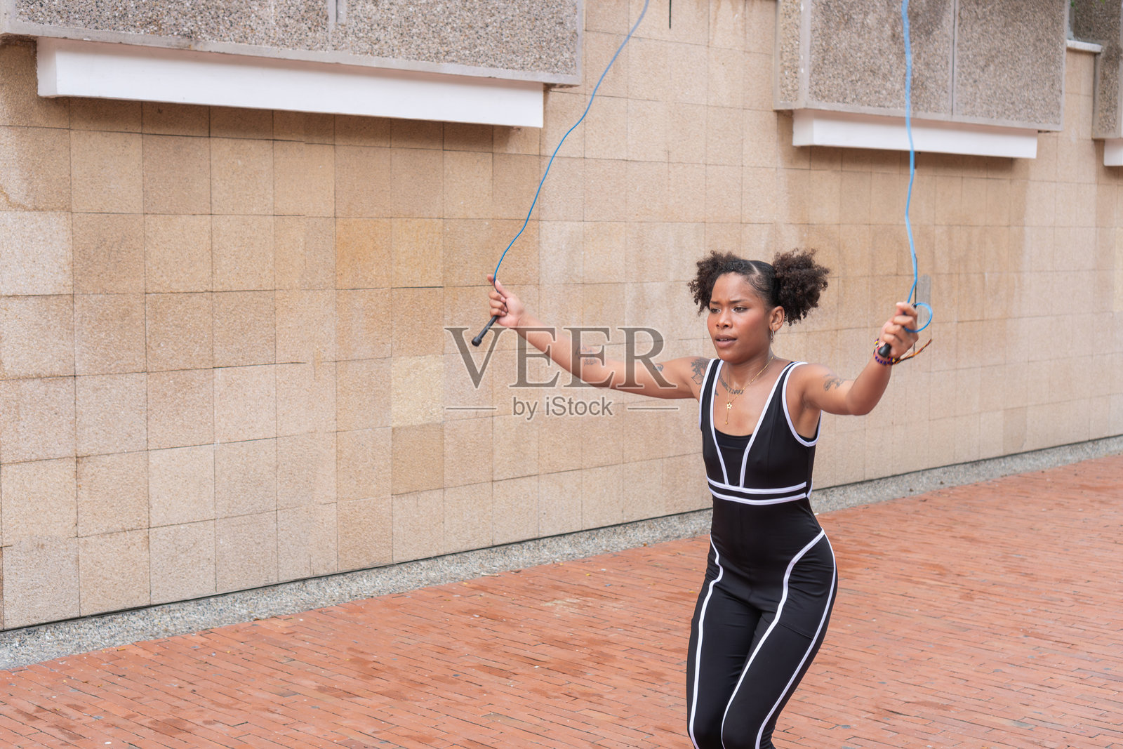 年轻的拉丁裔女性在城市环境中跳绳照片摄影图片