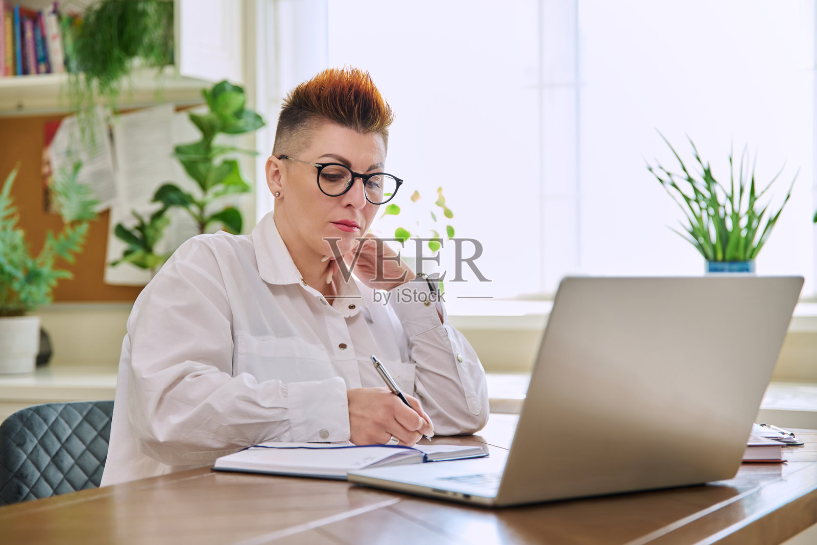 中年女性在家办公的工作室里处理电脑文件照片摄影图片