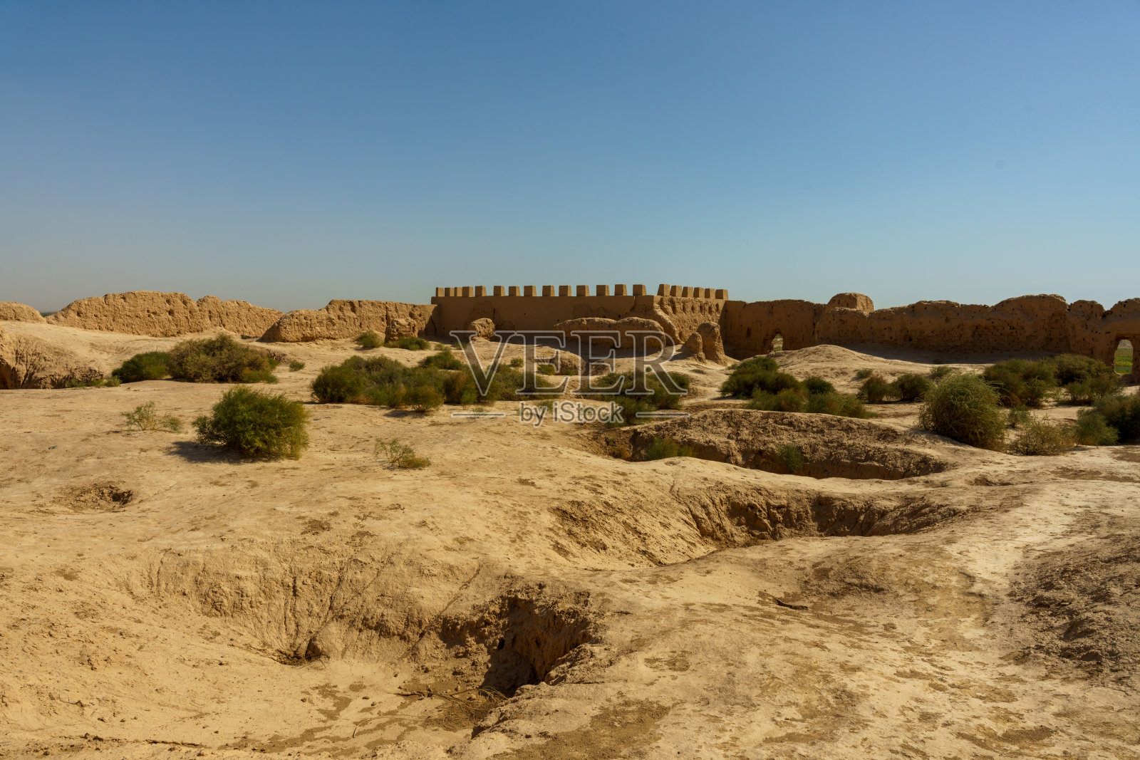 沙漠景观，远处有一面高墙照片摄影图片