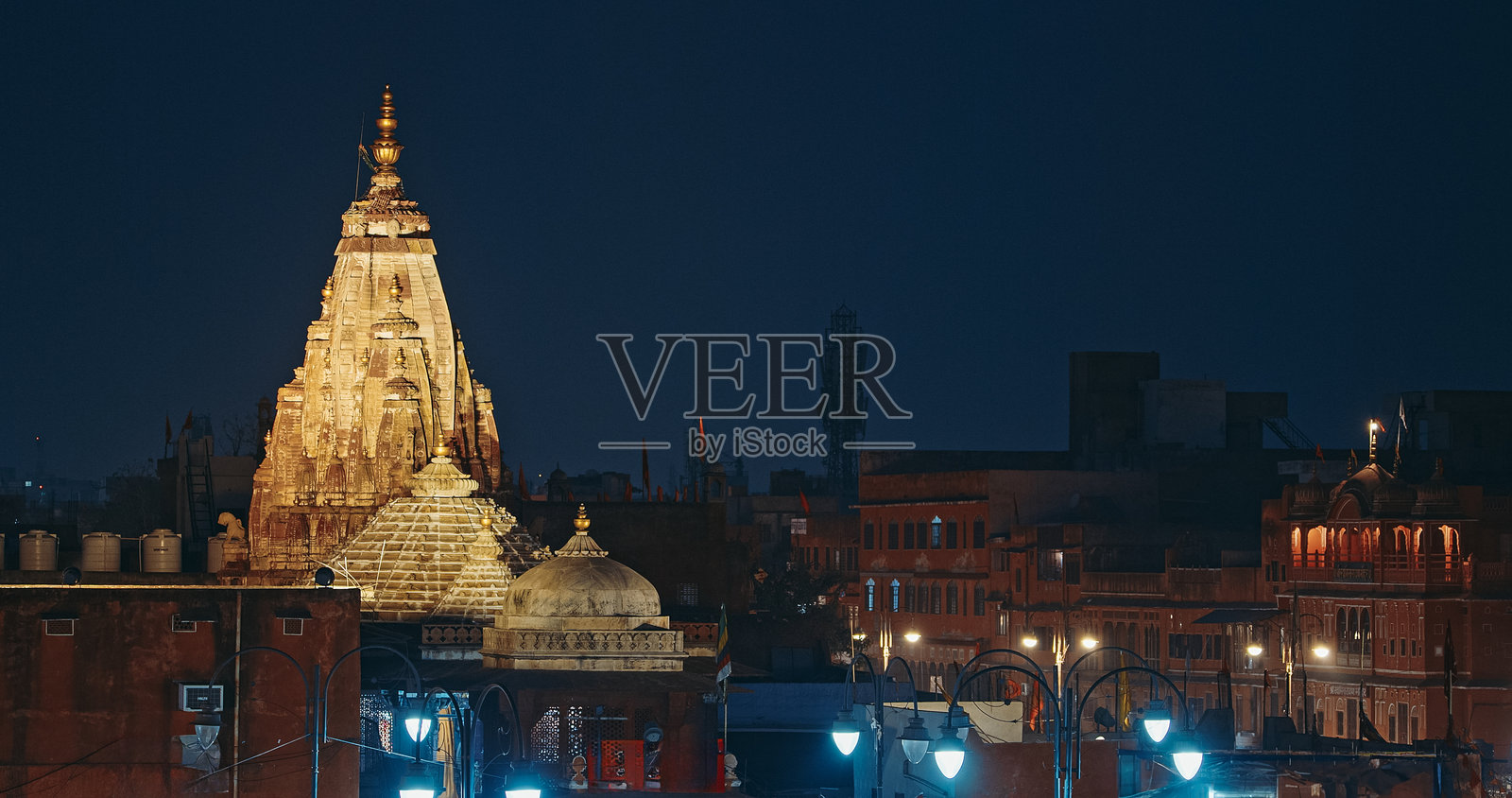 印度拉贾斯坦邦斋浦尔。夜间灯光下的西塔拉姆寺。寺庙位于小乔帕市场。寺庙的尖顶有多个称为安嘎尖顶的塔楼。尖顶上方有一个大型的阿玛拉卡和美丽的水瓶型顶饰。照片摄影图片