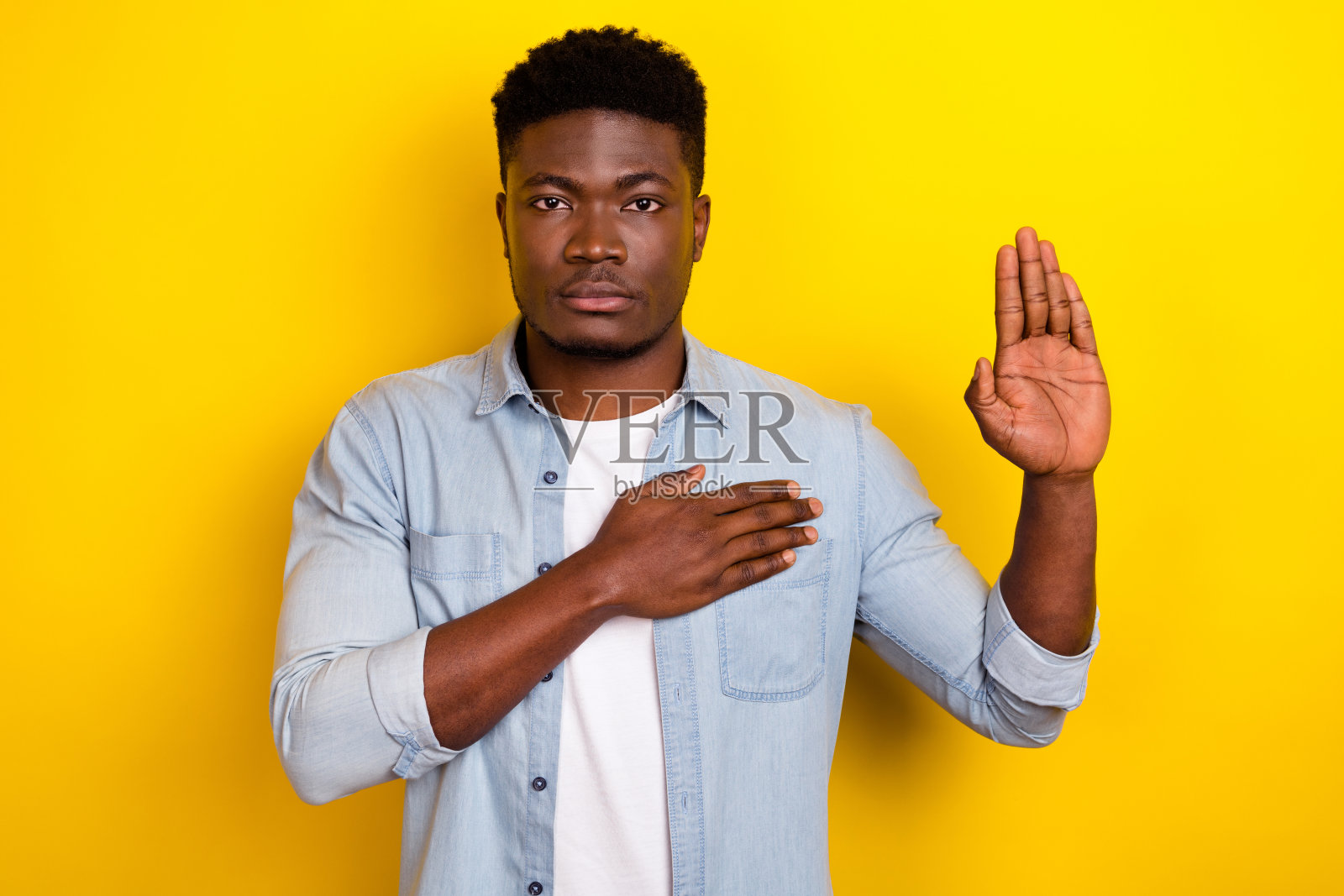 可信赖的男士在鲜艳的背景下倾听国歌并宣誓，双臂交叉于胸前。照片摄影图片