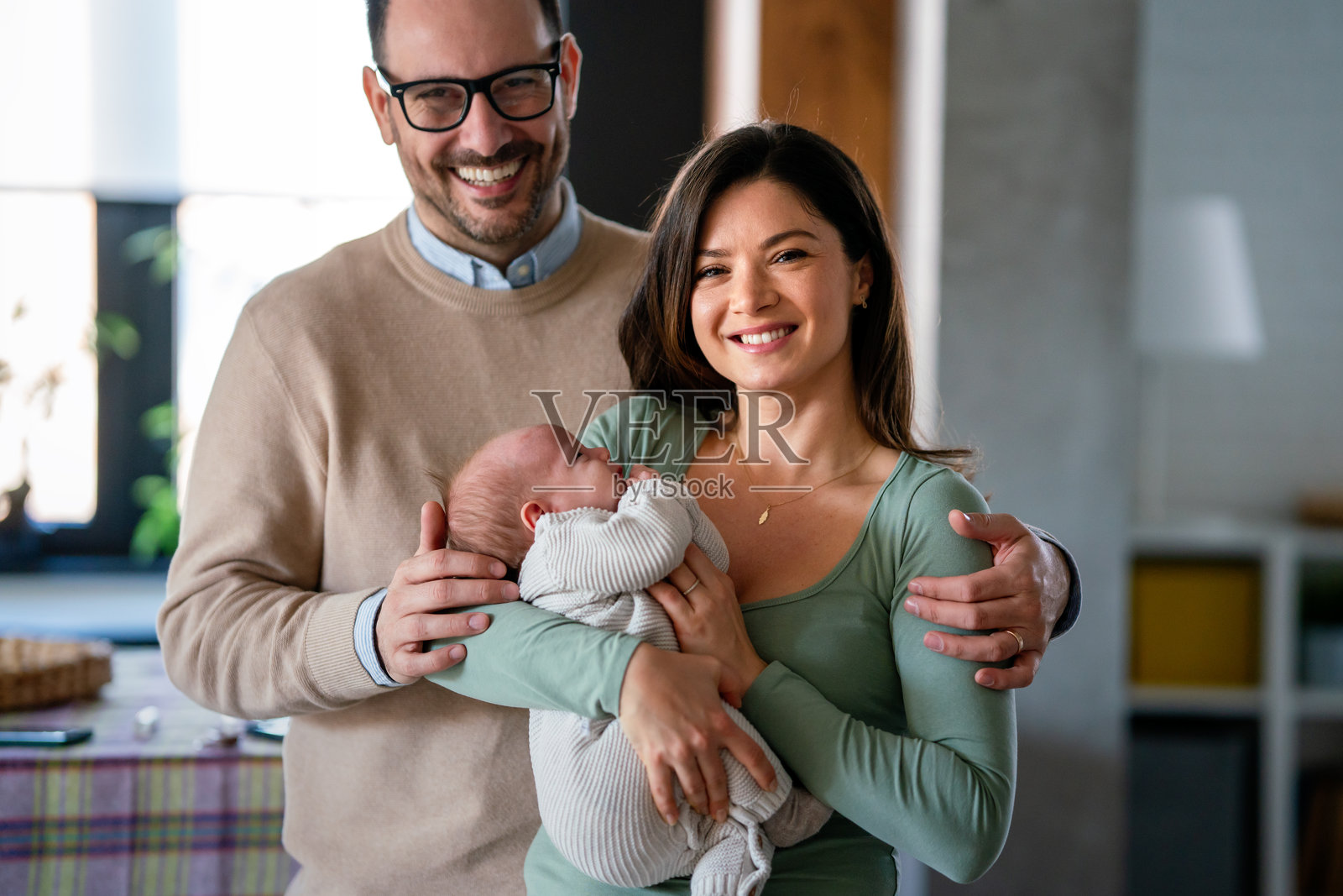 家庭、收养、婴儿、父母和人们的概念。快乐的父母与新生儿在家中。照片摄影图片