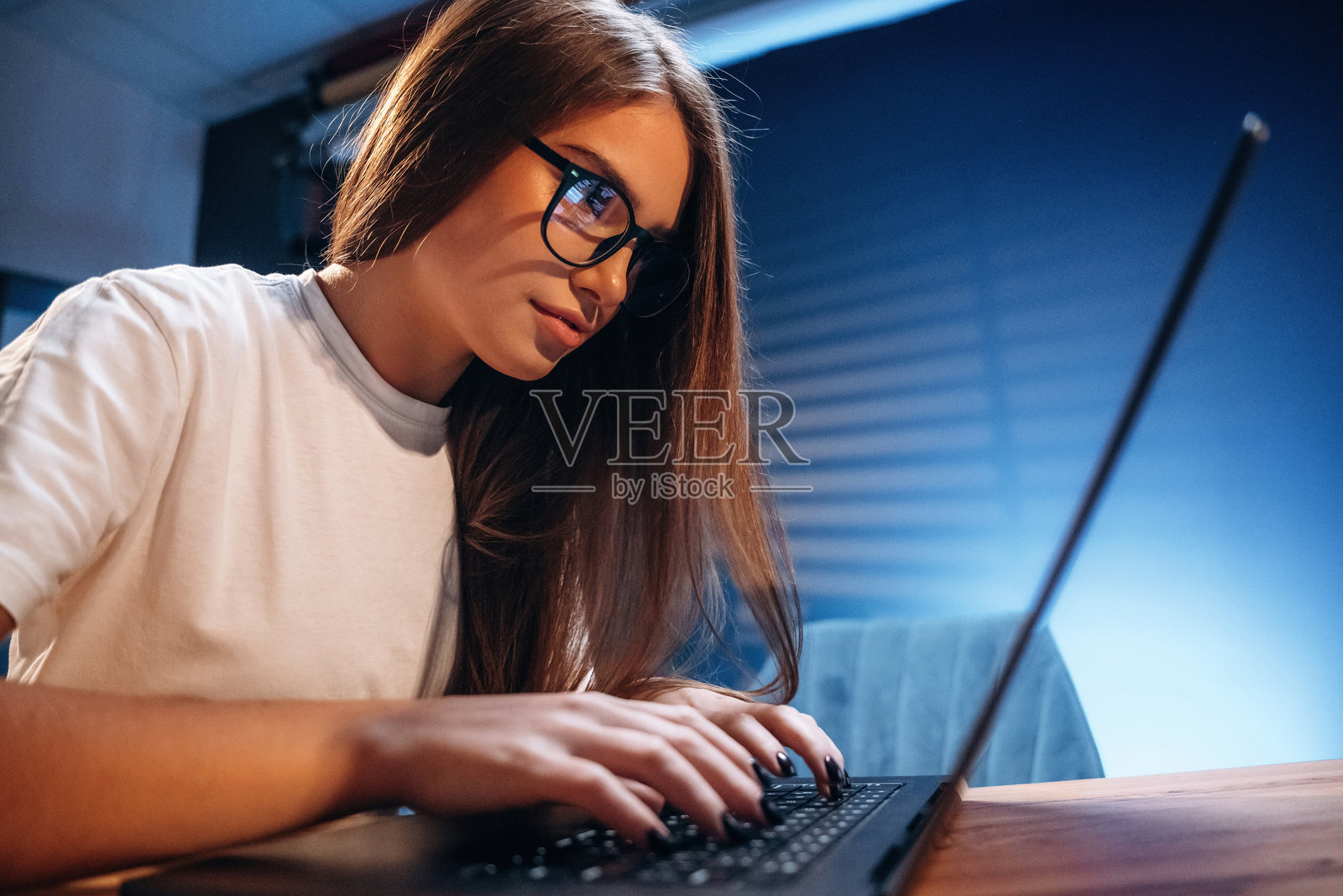 女性程序员，IT工作者坐在笔记本电脑旁照片摄影图片