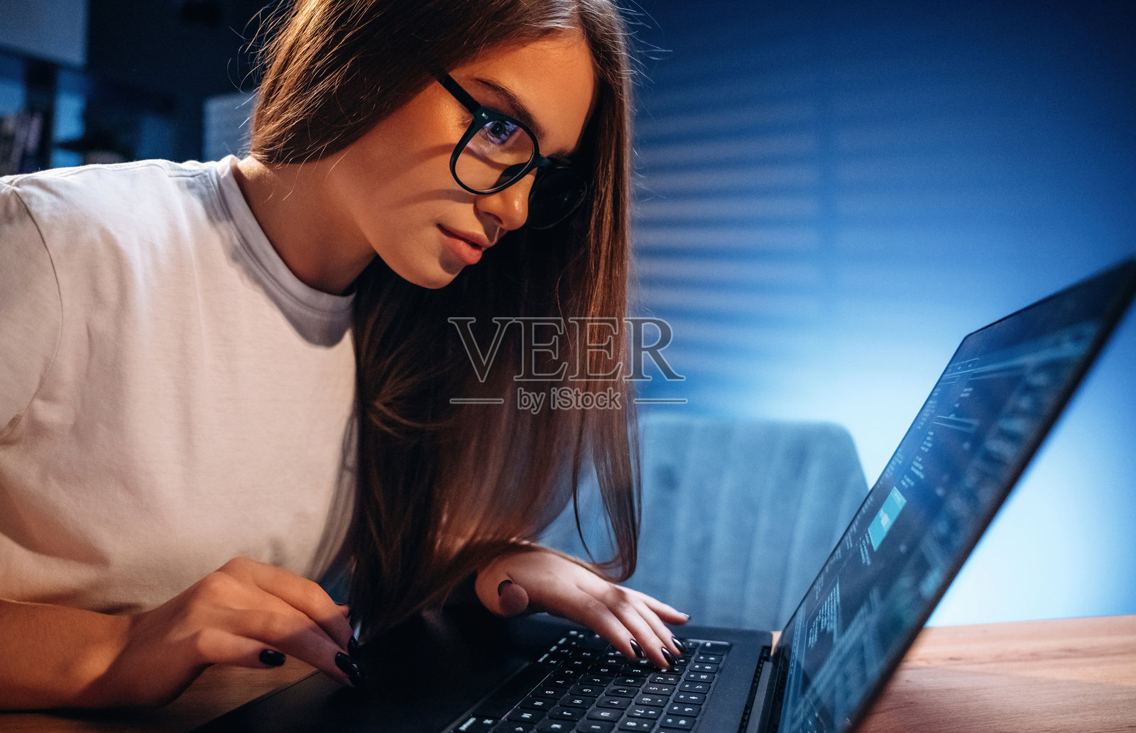 女性程序员，IT工作者坐在笔记本电脑旁照片摄影图片