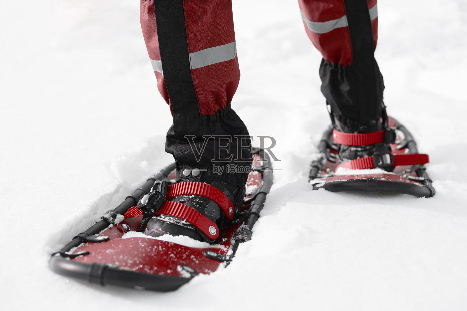 男子穿着雪鞋在雪地上行走照片摄影图片