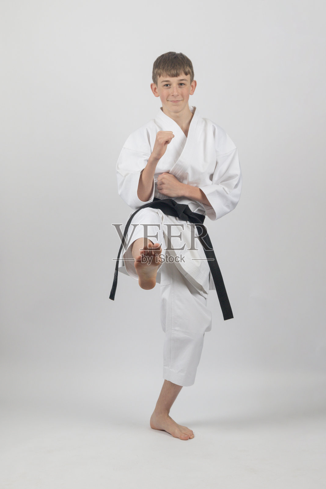 男青少年空手道黑带正在踢腿照片摄影图片