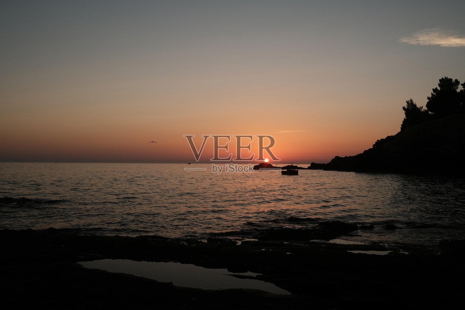 伊斯特拉州维鲁德拉海滩的海平面日落。照片摄影图片