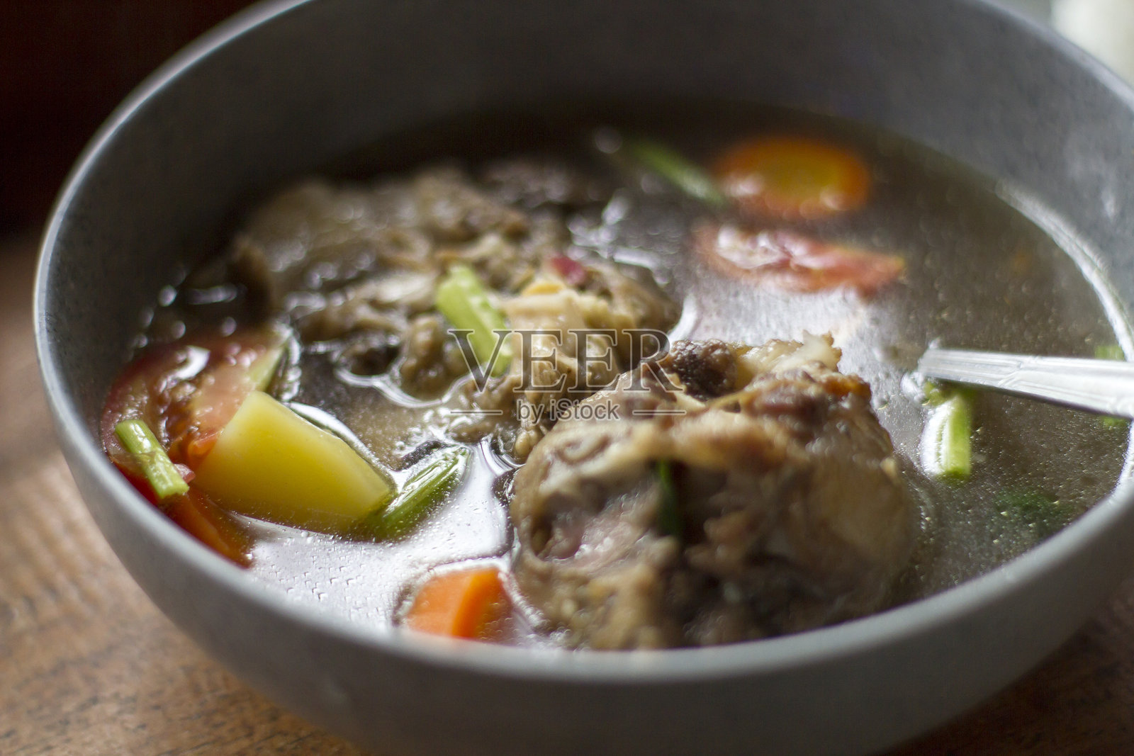 木桌上的SOP Buntut或牛尾汤，传统印尼美食。照片摄影图片