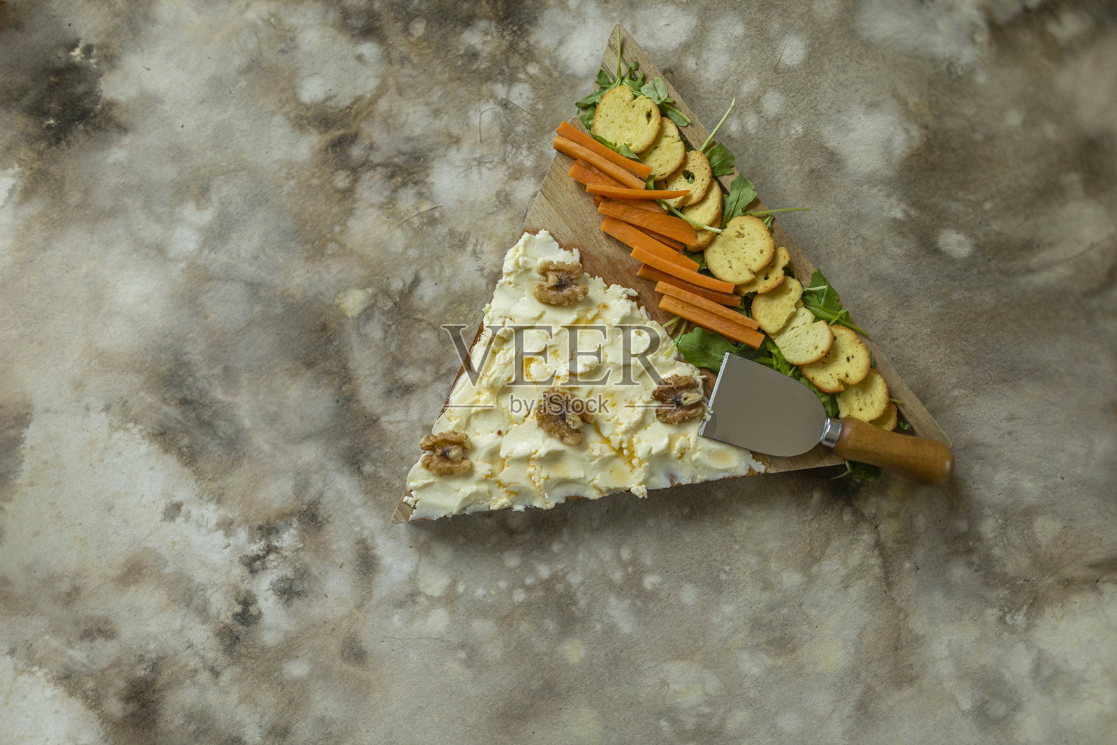 三角形木板上的黄油、饼干和胡萝卜，俯视图。照片摄影图片