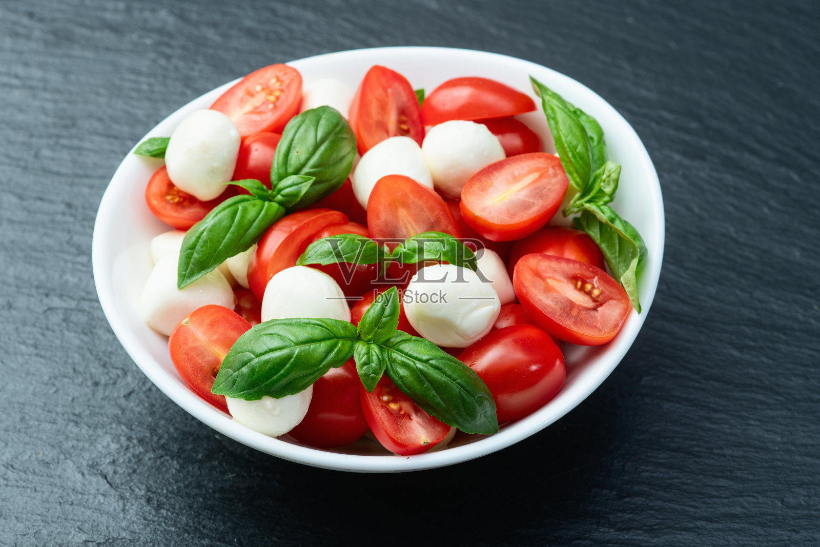 罗勒叶、樱桃番茄和马苏里拉奶酪。碗中的美食摄影照片摄影图片