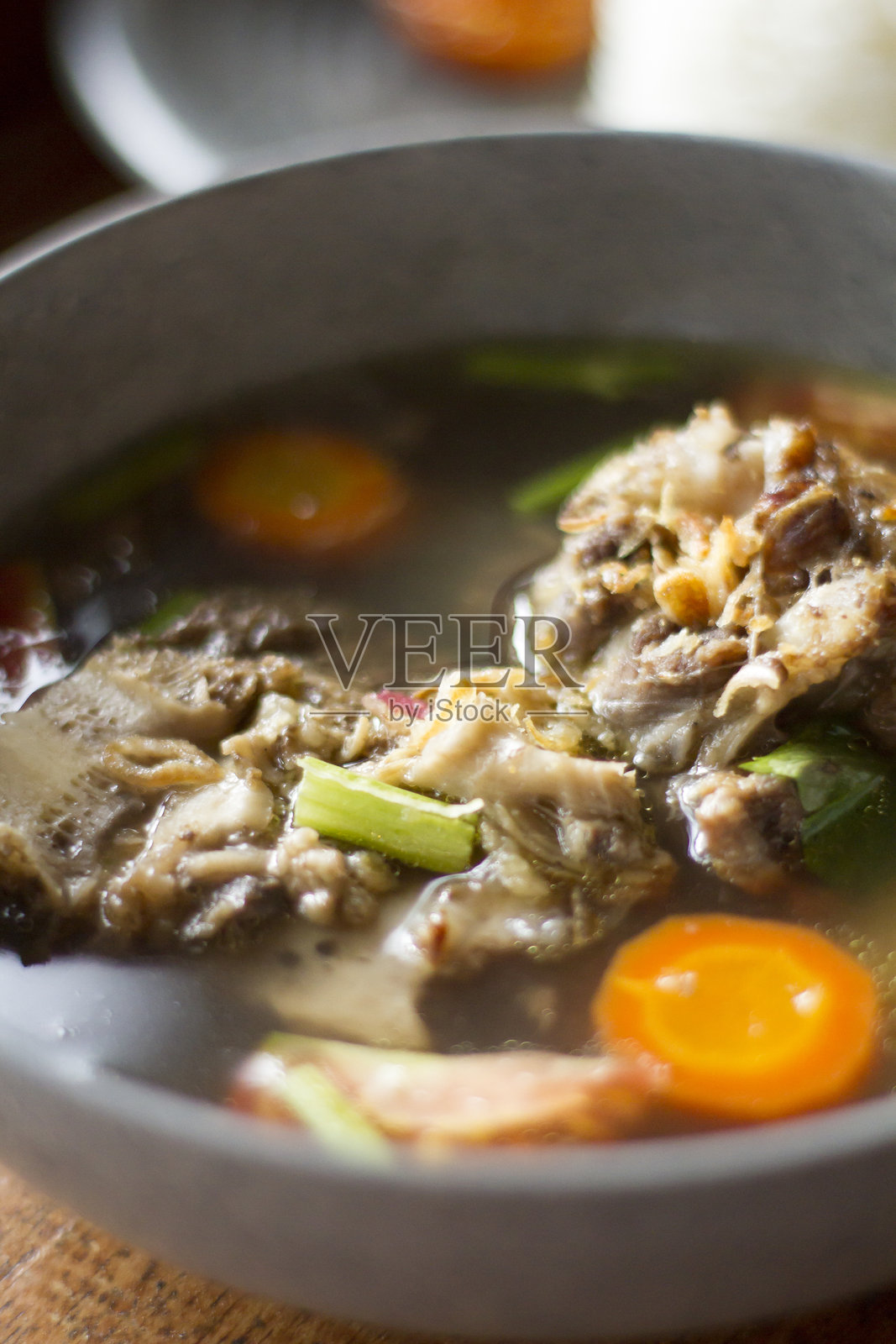 木桌上的SOP Buntut或牛尾汤，传统印尼美食。照片摄影图片