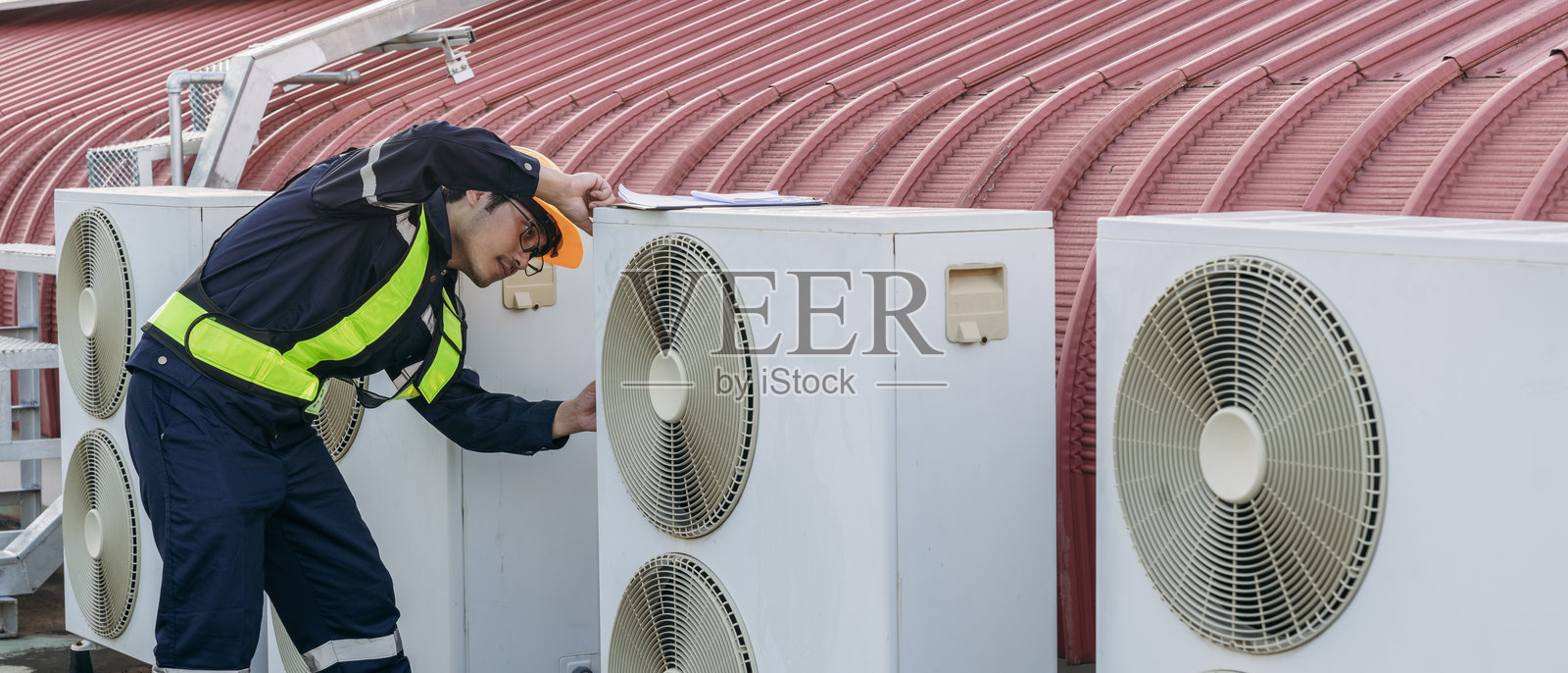 工程师正在检查大型建筑或工业设施的空调冷却系统。照片摄影图片