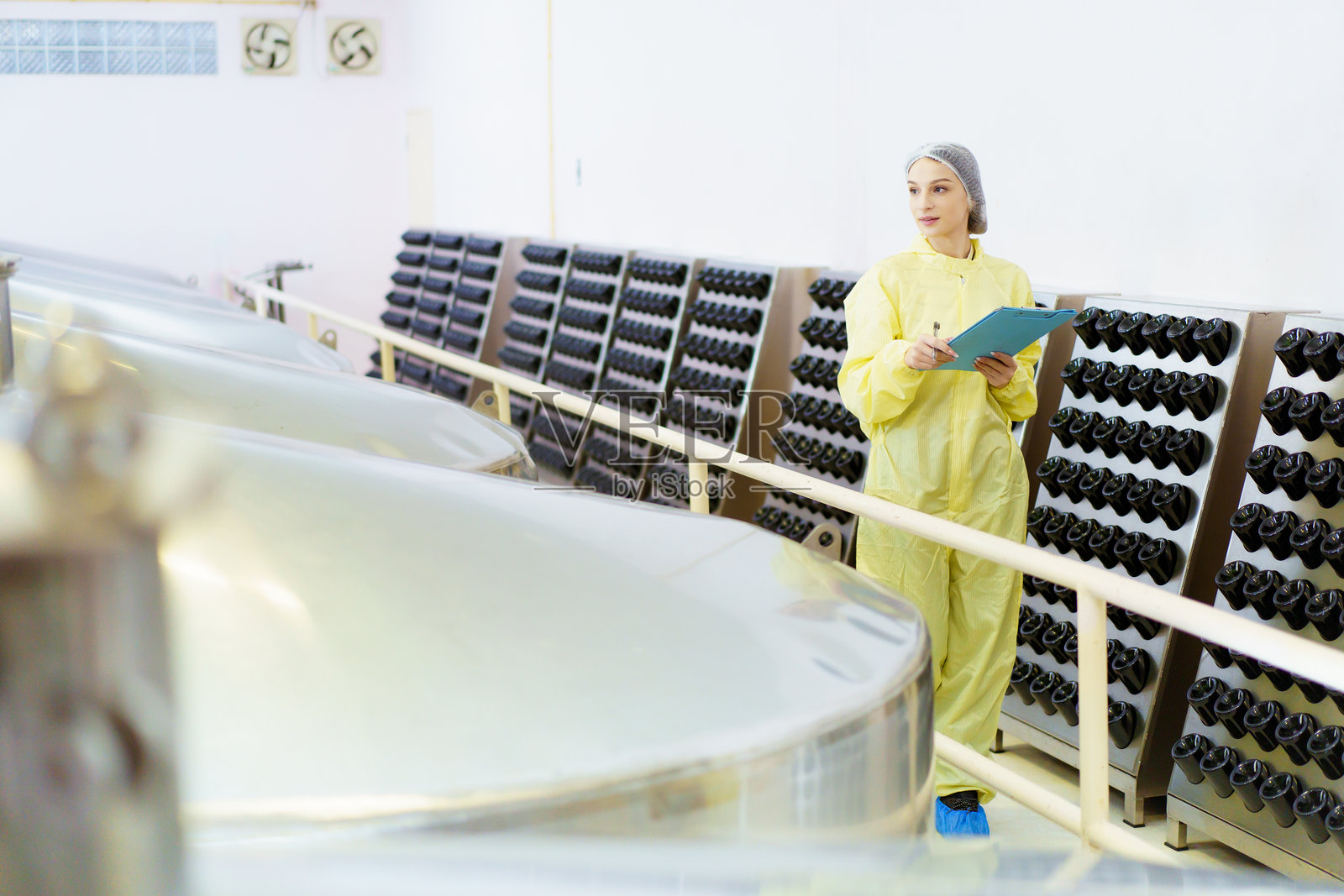 质量控制员在饮料制造工厂进行检查。照片摄影图片