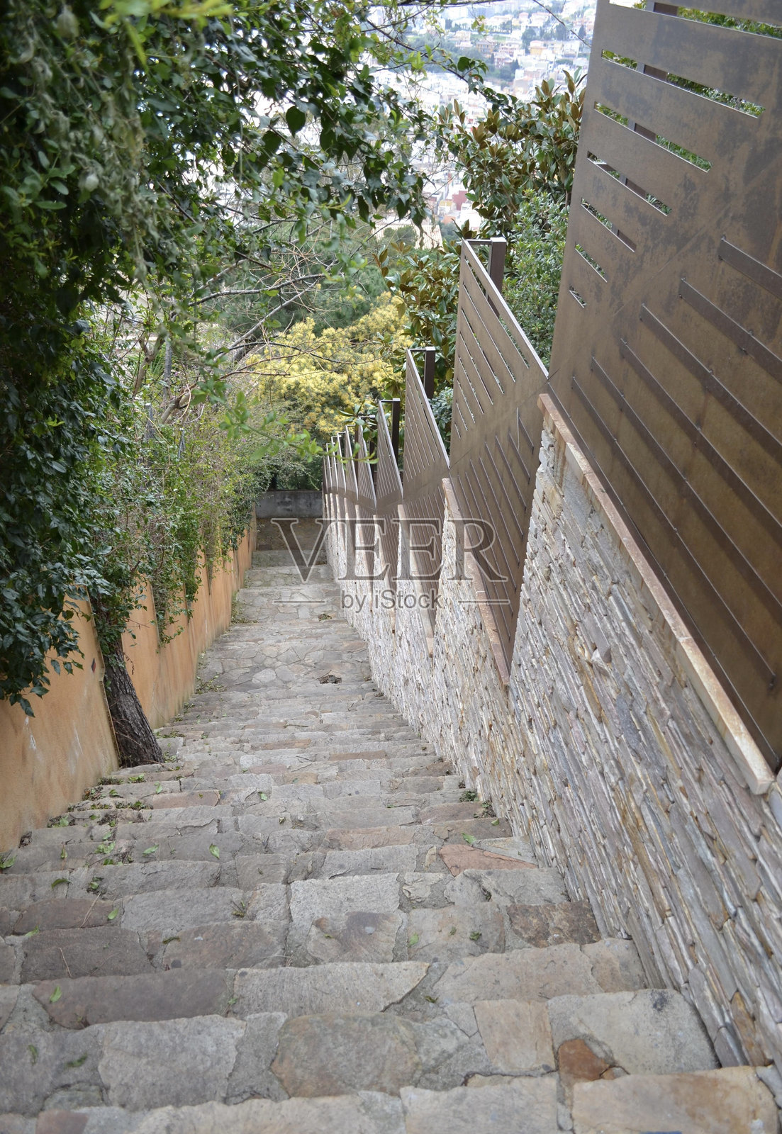 一条陡峭的街道，石阶向下延伸。照片摄影图片