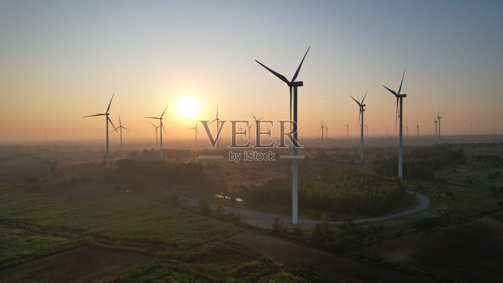 日落田野中的风力涡轮机正在产生清洁能源照片摄影图片