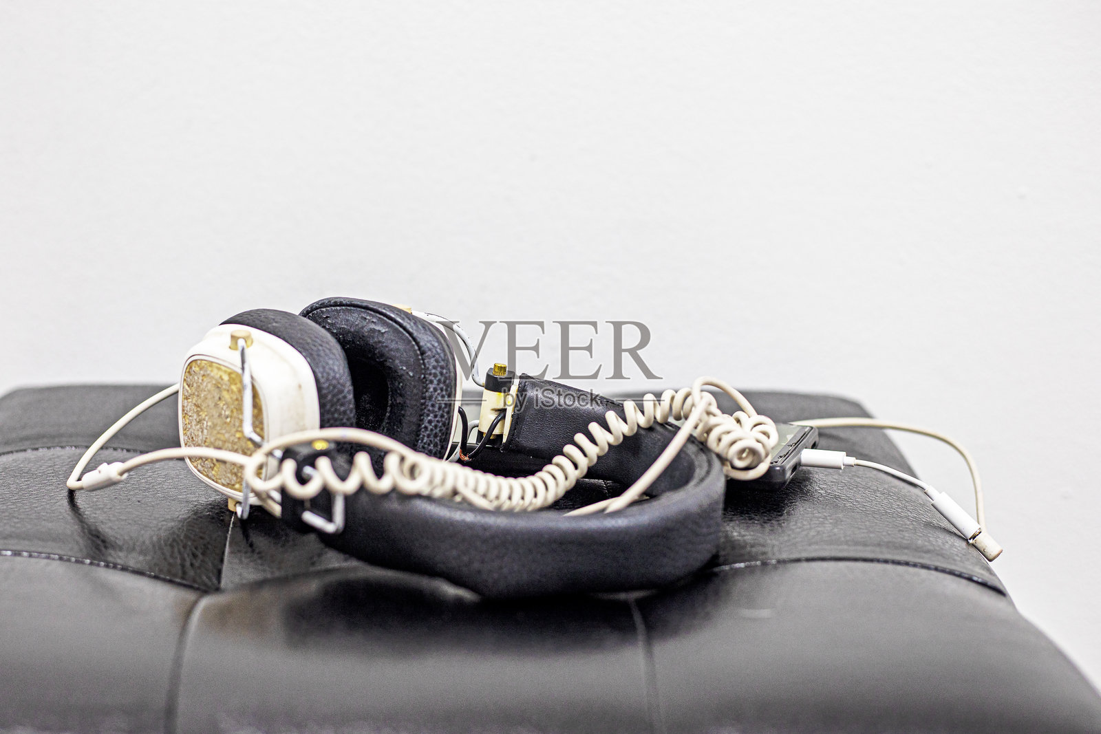 青年耳机与放在脚凳上的手机照片摄影图片