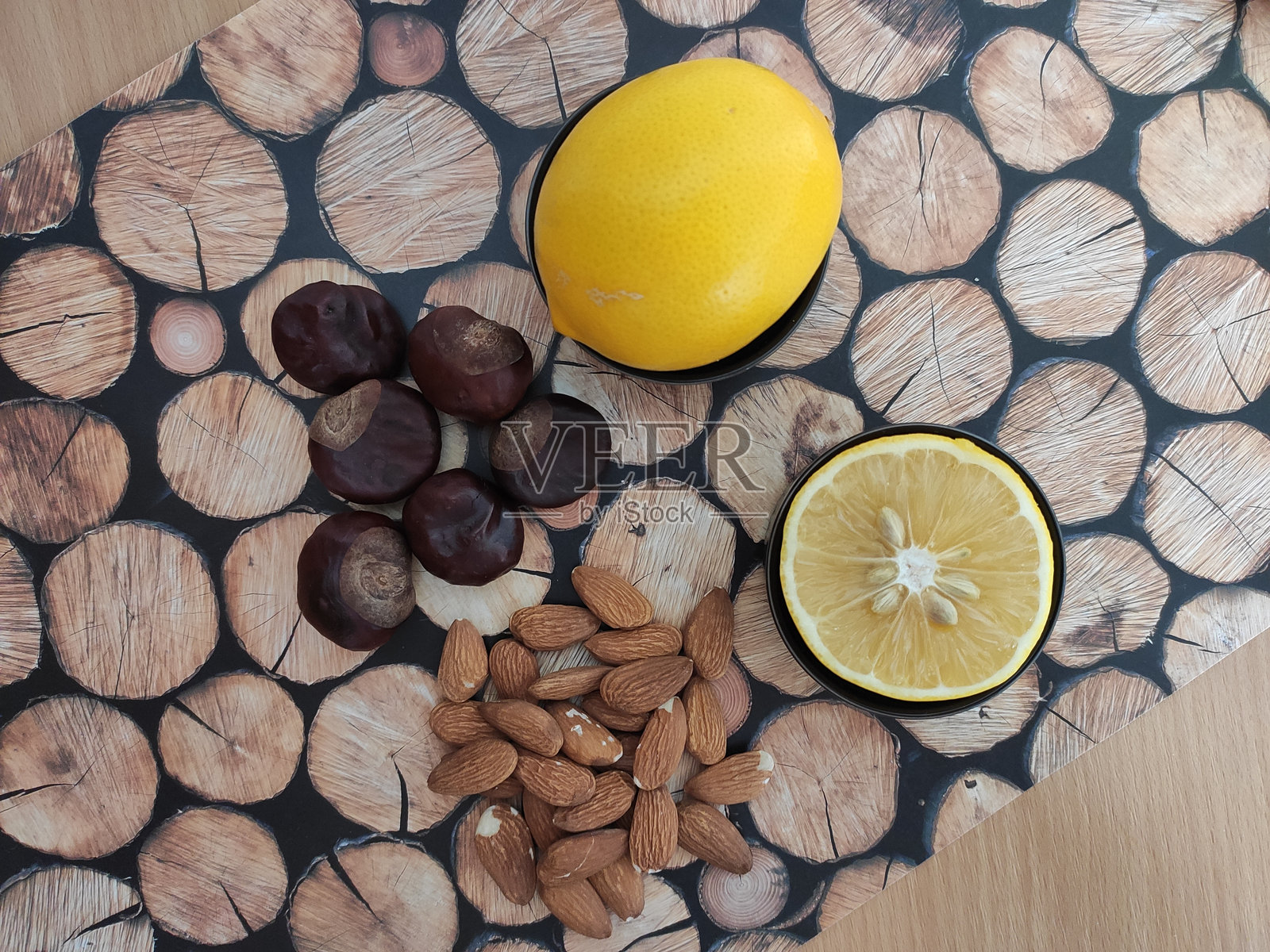桌子上的黄色柠檬、杏仁和闪亮的棕色栗子照片摄影图片