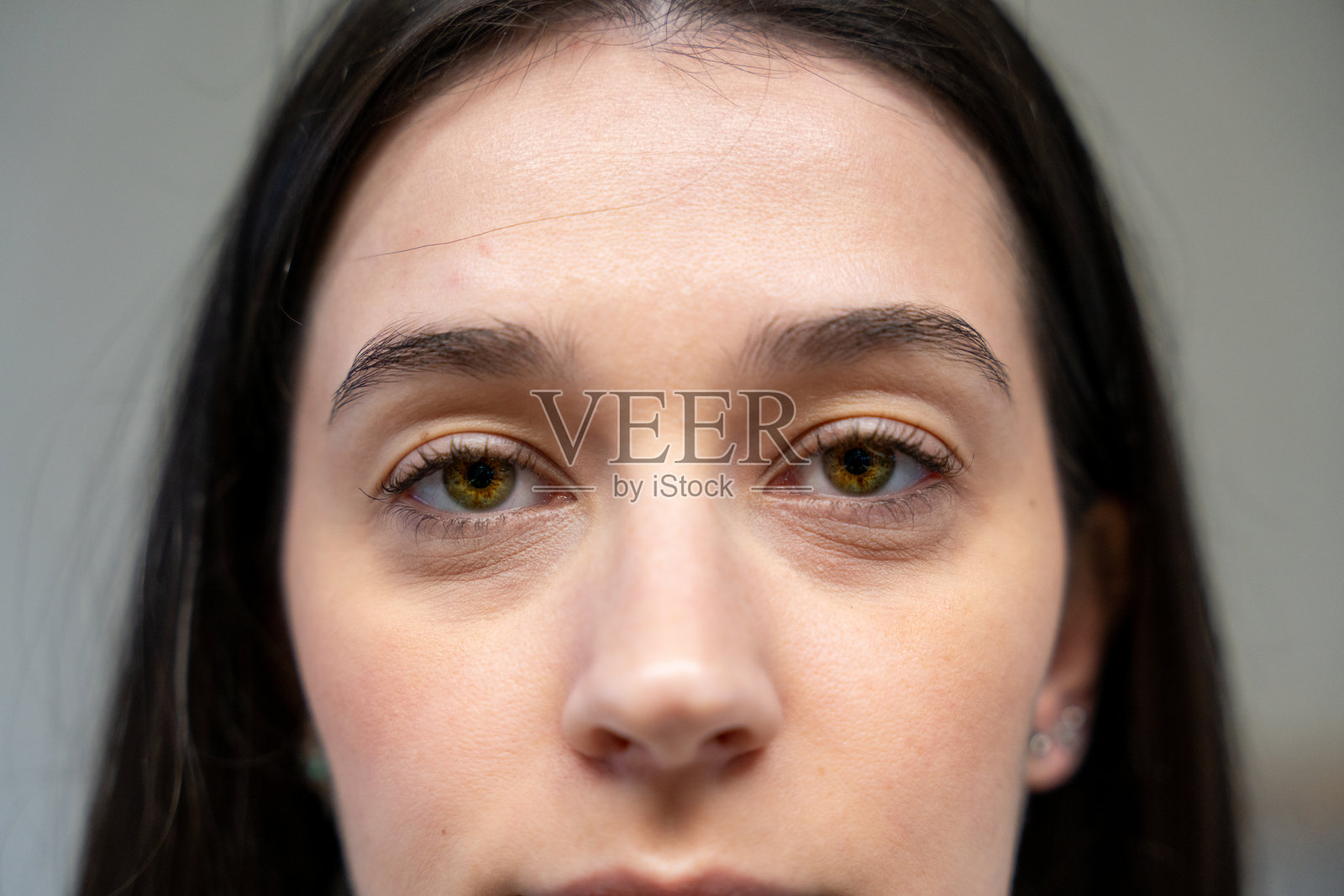 年轻女性用褐色眼睛和黑色头发凝视镜头照片摄影图片