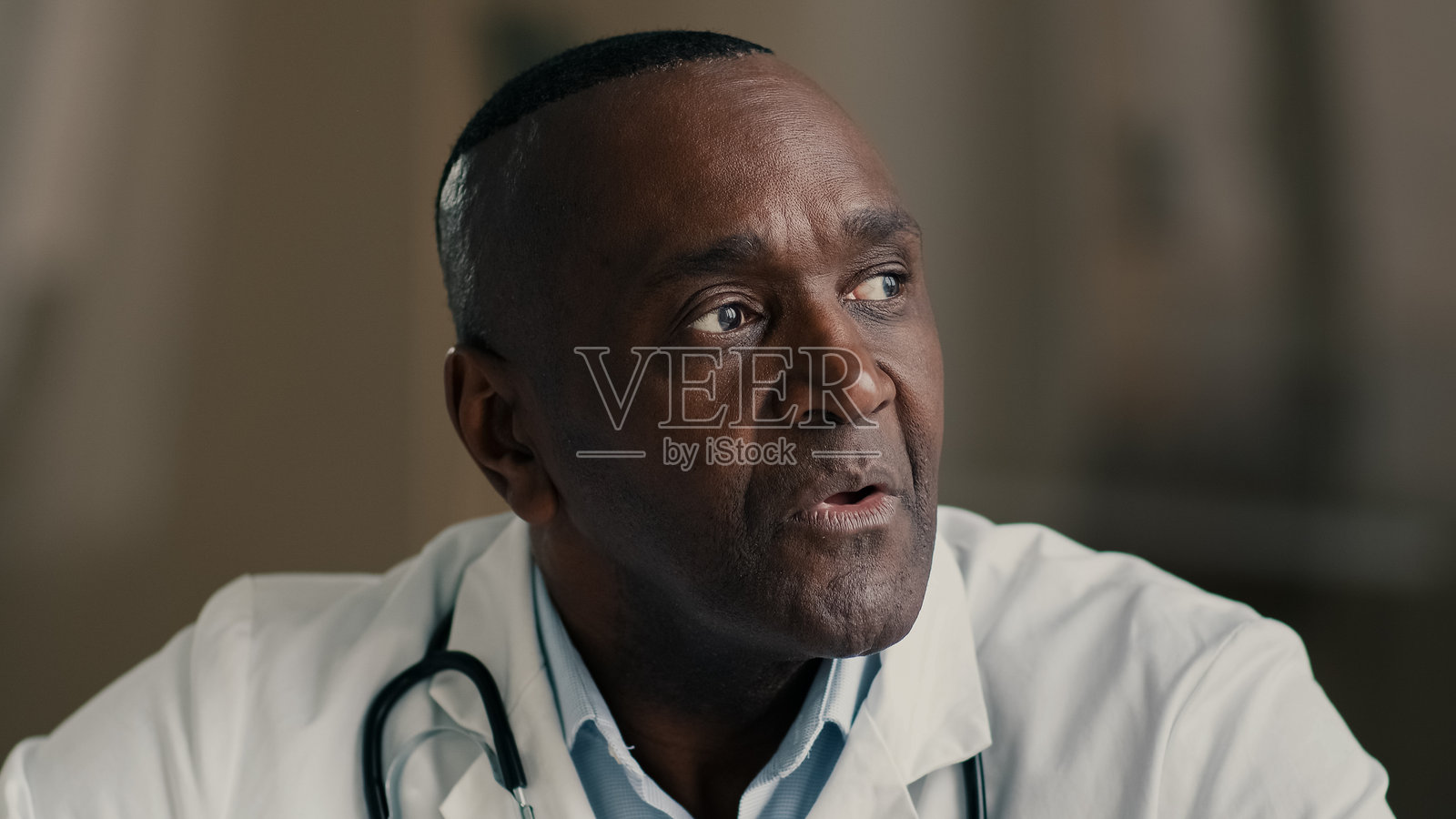 困惑而深思的年长男性专业医生，成熟的非裔美国人穿着白大褂，正在策划创意，进行头脑风暴，思考医疗和健康概念。照片摄影图片