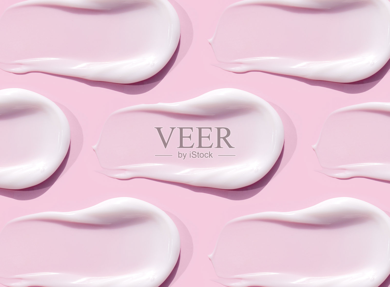 粉色背景上的化妆品涂抹纹理奶油图案照片摄影图片