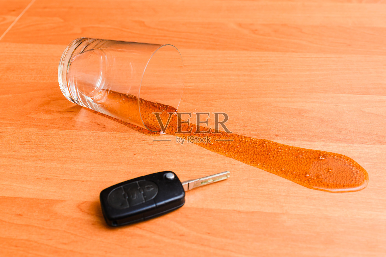 家里的汽车钥匙、酒精、玻璃桌和啤酒罐。照片摄影图片