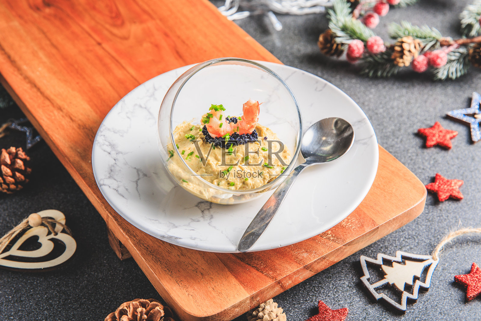 圣诞节装饰的鳄梨虾仁粉红色鲜奶酪鳄梨酱细香葱奶油和鱼子酱杯照片摄影图片