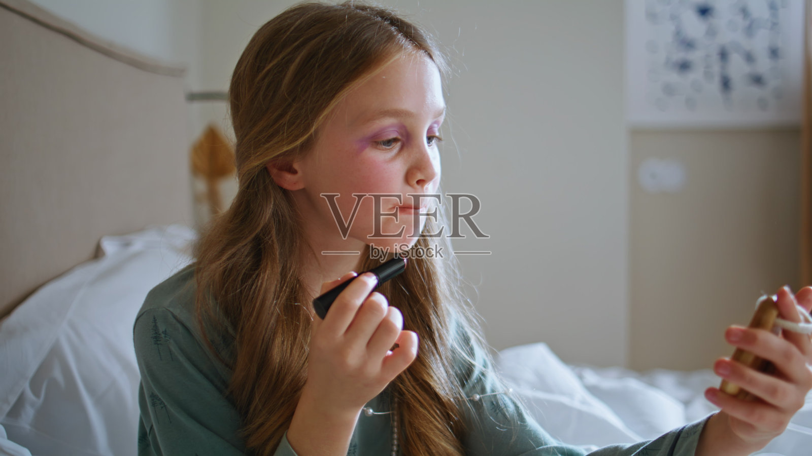 小女孩在妈妈的房间里化妆特写。小孩子在涂口红。照片摄影图片