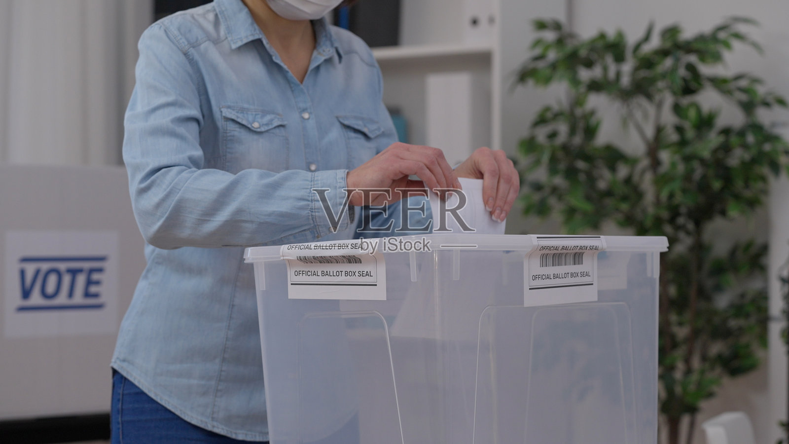 在疫情期间，市民们佩戴防护口罩负责任地投票。照片摄影图片