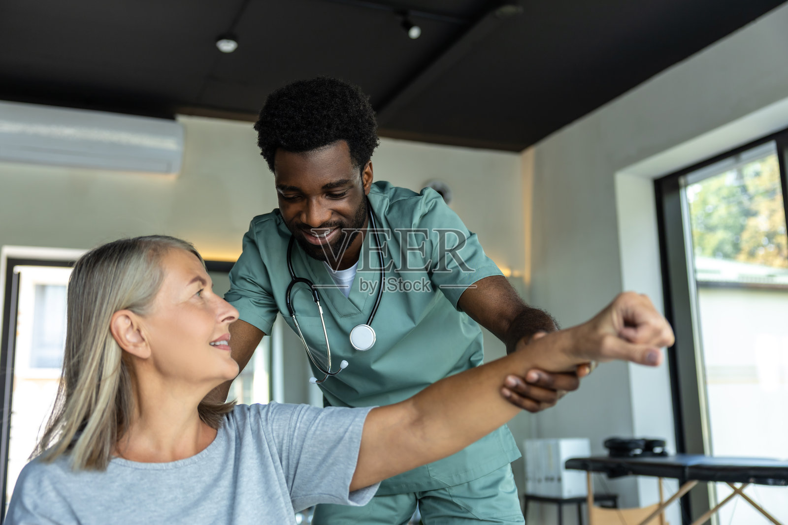 医生使用物理治疗技术为成年患者缓解疼痛照片摄影图片